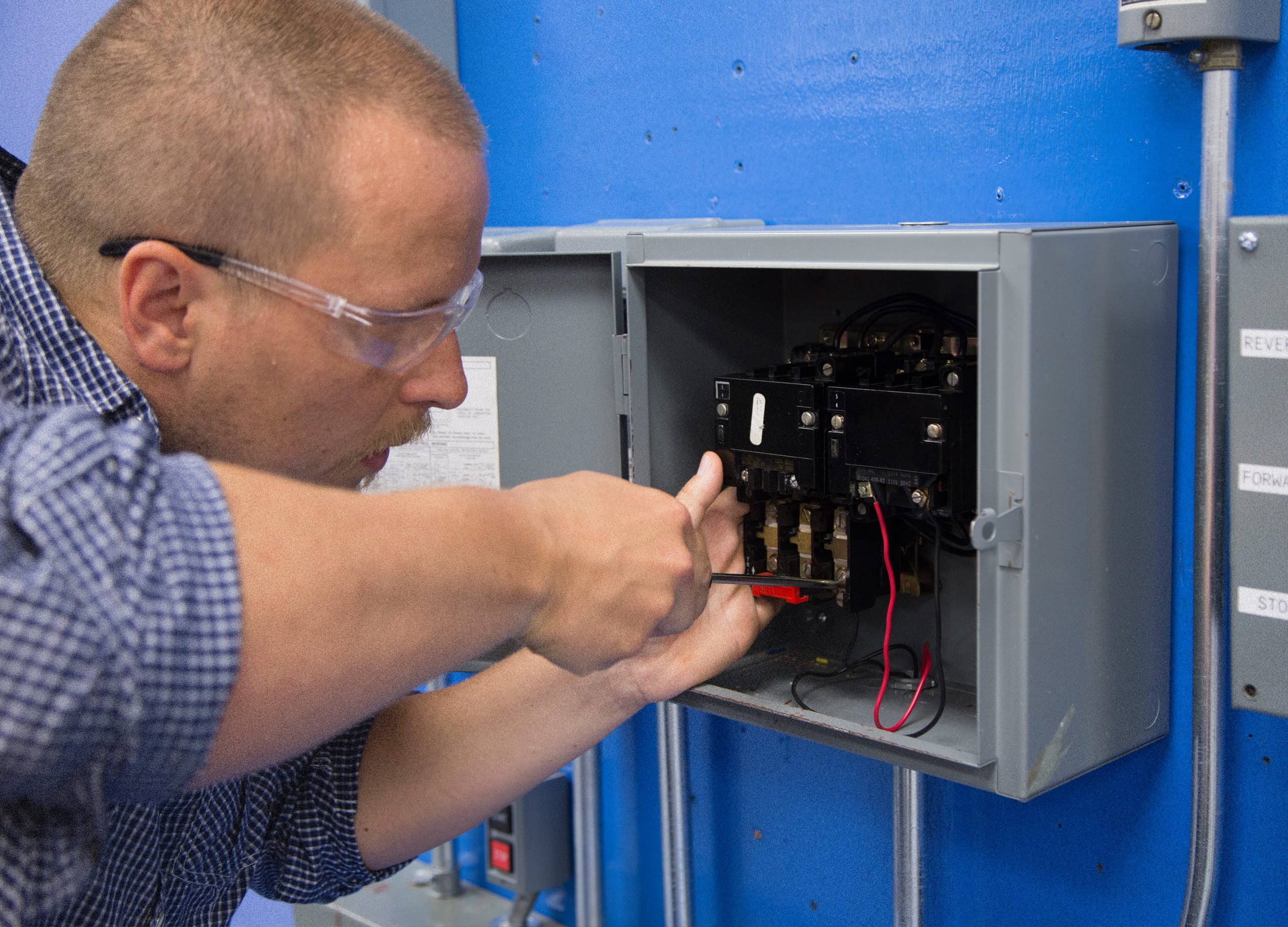 Electrical Engineering Technician student working on a panel